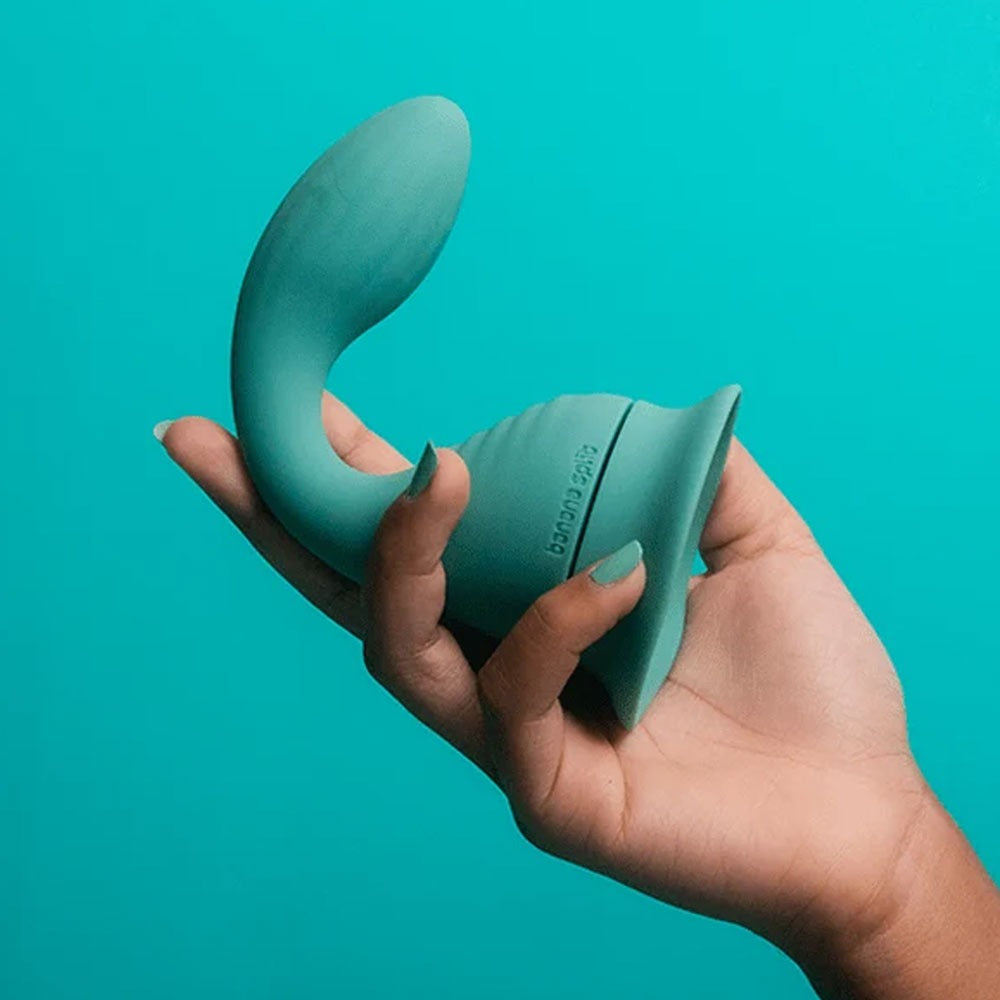 Banana Split dollop vibrator with its included suction base for stand alone use, in a hand
