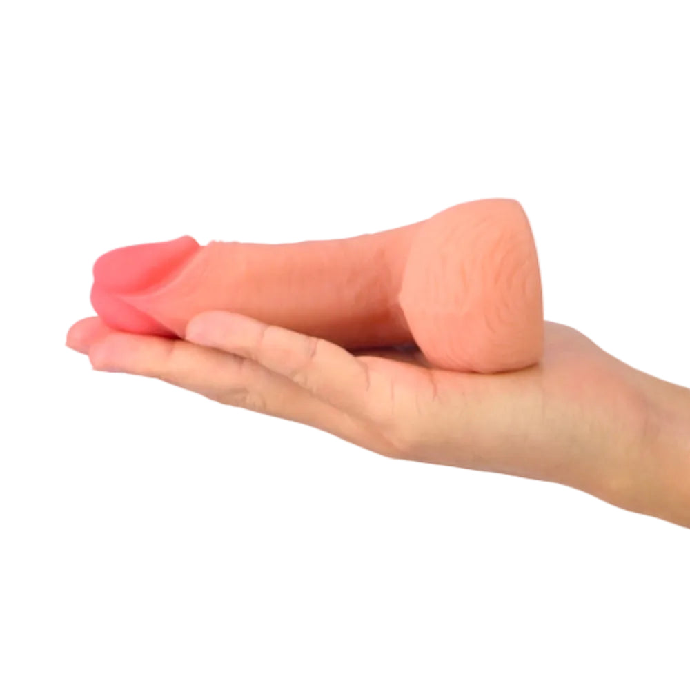 Love toy 5.5 inch dual layer TPE packing penis form the side laying flt in an outstretched palm