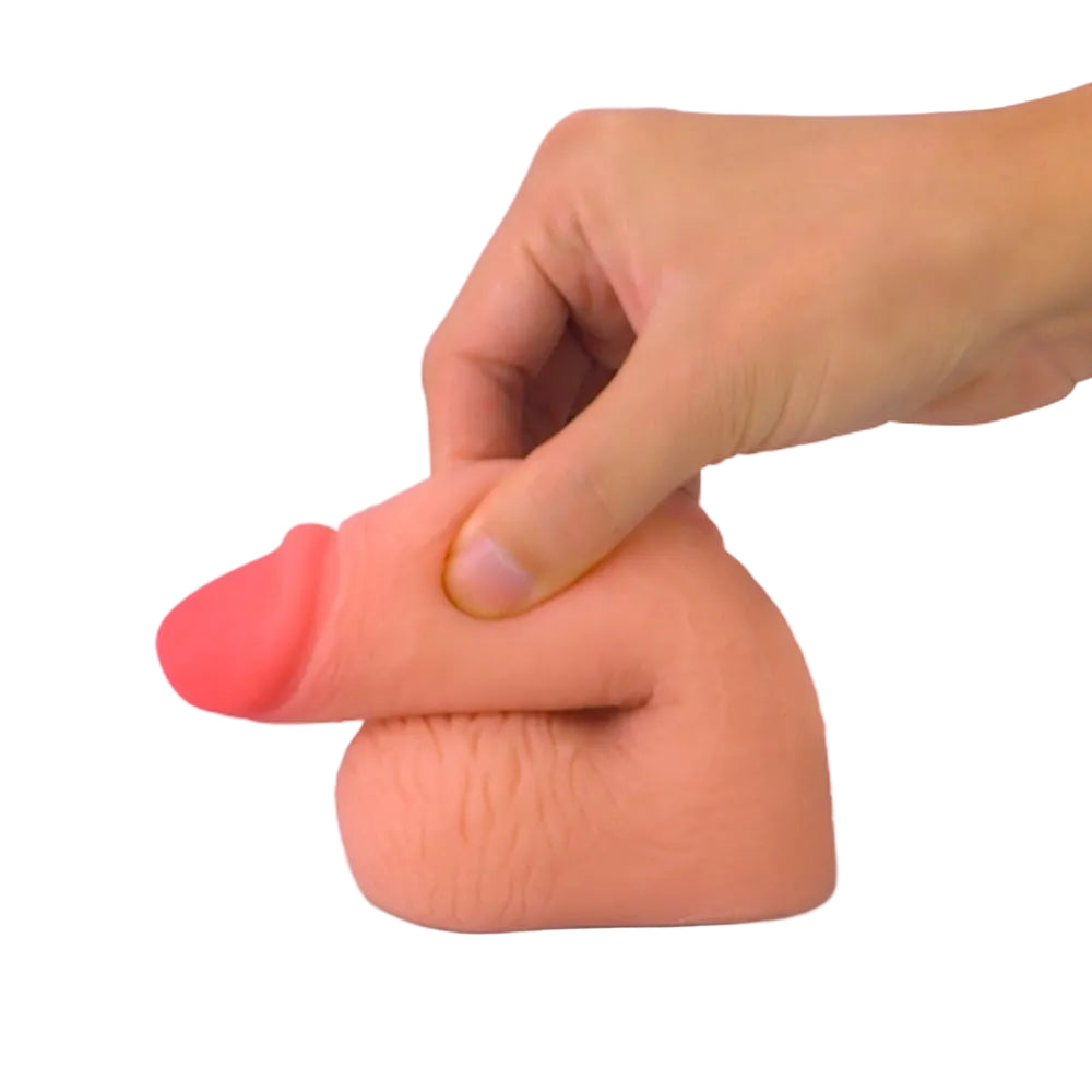 Love toy 5.5 inch dual layer TPE packing penis form the side in a flaccid position Being pinched to show soft texture