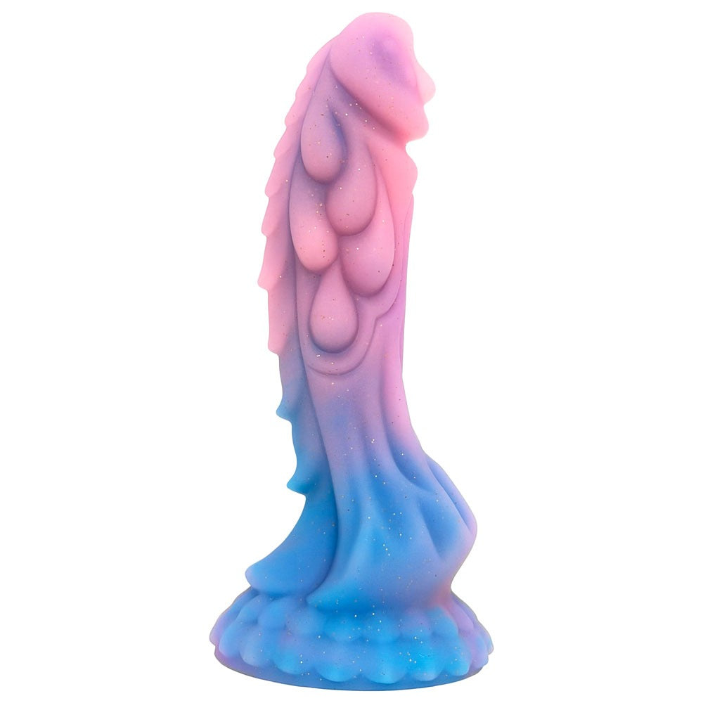 nexus Theron reptilian fantasy dildo in dusk, with an ombre swirl pink and blue and gold glitter. sculpted reptile scale details, from the side on its suction cup base